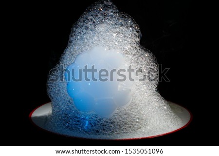 A mountain of a large number of different size and shape soap bubbles on a black background. Magical performance. Magic tricks. Rainbow soap bubble. Colored large balls. Holiday. Christmas Soap bubble