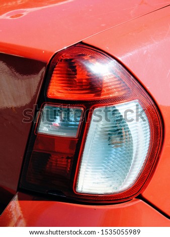 Close-up image of a car tail light on a red automobile
