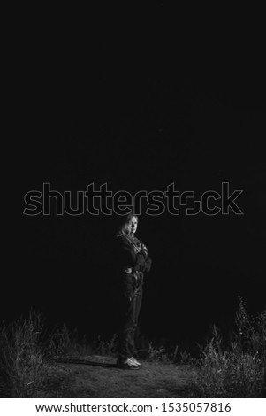 Alone woman at night time, dark darkness outside. vertical photo