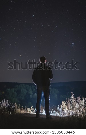 man alone look at the sky full of stars, romantic atmosphere. travel. peak, vertical photo