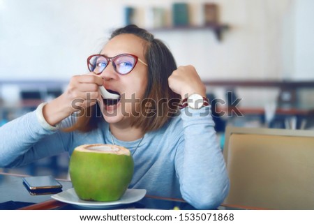 A beautiful Asian woman is eating coconut in a restaurant.
