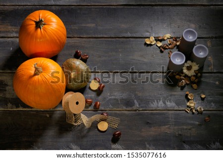 Pumpkins and blue candle on wood background