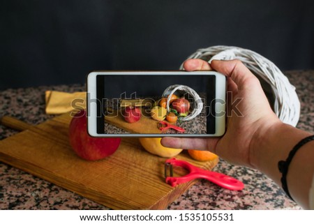 Stock photo of a smartphone taking a picture of a fruit still live. Health, food
