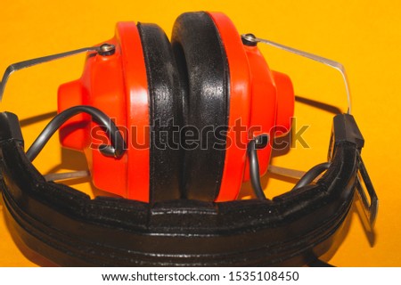Vintage red headphones on yellow background. retro earphones