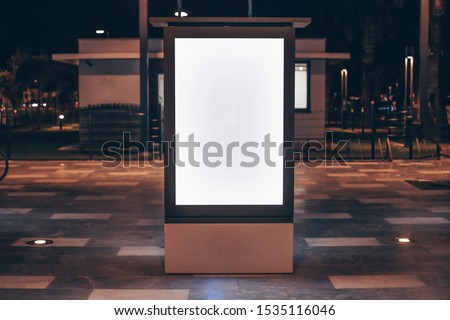 Street advertising mock up template with copy space. Outdoor commercial banner with white empty display on the night street