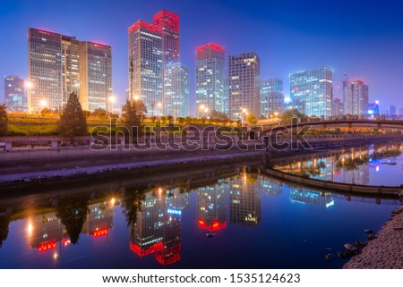 Beijing, China CBD city skyline and canal at night.