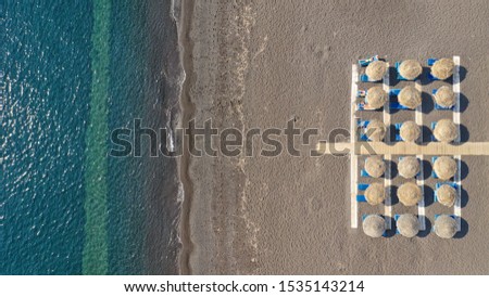 Aerial drone top down photo of organised Mediterranean sandy beach with sand beds and umbrellas