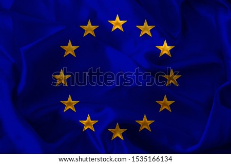 close-up photo of beautiful colored stylized European Union flag, symbol of united Europe on textured fabric, concept of tourism, emigration, economy and politics, close-up