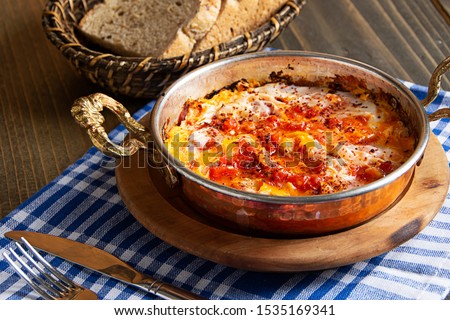 Traditional turkish food menemen, made by eggs, tomatoes, sesame and various spices. Royalty-Free Stock Photo #1535169341
