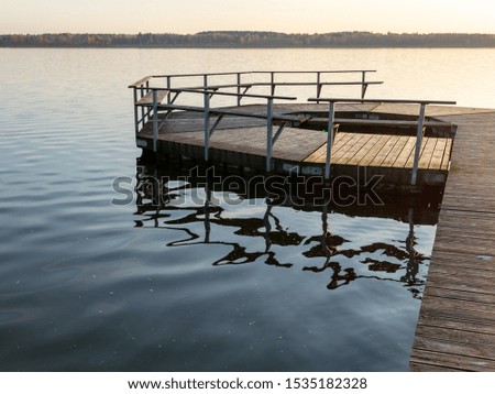 picture with a wooden footbridge on the lake in sunset light