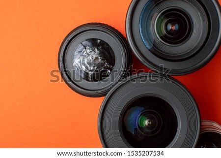 broken modern photo lens on a colored background, photographic equipment repair concept, copy space