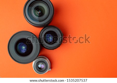 Progress of different photo lenses on a colored background, a set of old and modern photo devices for the camera, copy space