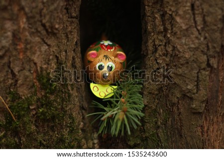 mouse looks out of the hollow tree