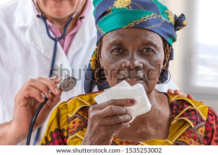 General practice doctor listening to a 70-year-old African woman's back. with stethoscope used to listen the heart and lungs