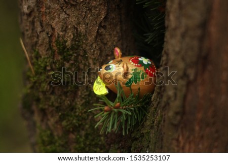 christmas mouse with cheese looks out of a hollow tree