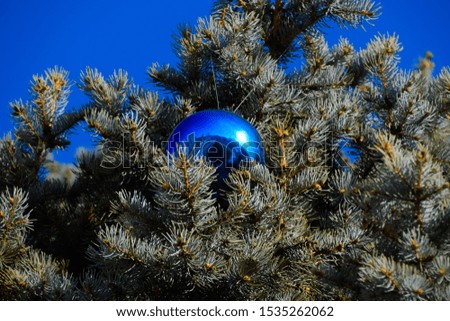 Tinsel and toys, balls and other decorations on the Christmas Christmas tree standing in the open air. Decorations New Year tree.