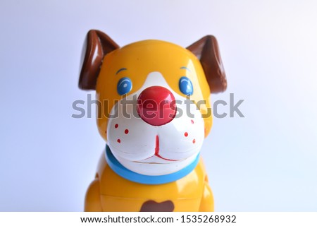 Close up of red-nosed dog-shaped kid's toy face with white background. Children's toys made of plastic shaped cute animals.