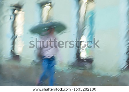 blurred motion big city people walk on road in rainy day