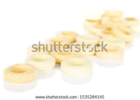 Lot of whole disordered round pale yellow candy isolated on white background