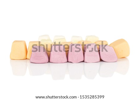 Lot of whole soft pastel candy in row isolated on white background