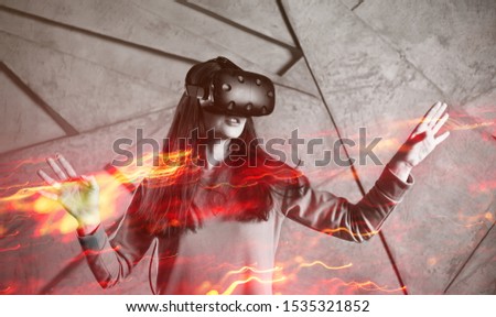 girl playing VR games, concept of modern technology, effect of double exposure. A young cheerful woman uses a virtual reality helmet. Deep dive into gaming reality, VR glasses