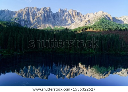 Panoramic view of Dolomites mountains at Carezza lake at Alto Adige or Sudtirol of Italy. Landscape with Karersee and Dolomiti of Alps, Sud Tirol. Alpine scenery of Tyrol. Nature in morning at sunrise