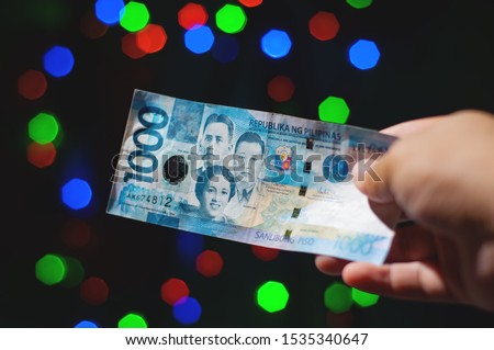 Giving a One Thousand Peso Cash on Christmas Day. A Filipino generous trait called Pamasko. 