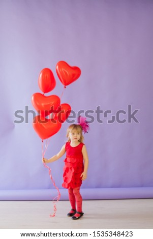 Little girl with red balloons at the holiday