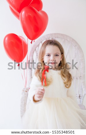 Little girl with red balloons on Valentine's Day