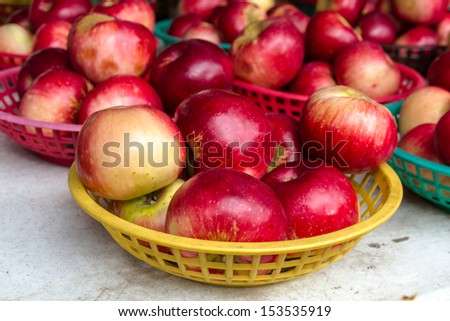 Organically grown red apples in basket with sign for sale at local farmers market