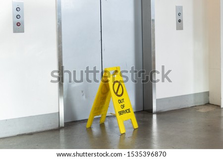 Elevator with an "Out of service" yellow sign in front of it.