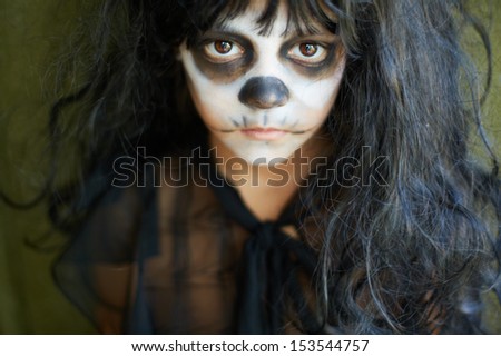 Portrait of spooky girl in Halloween attire looking at camera