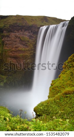 Beautiful waterfall landscape with green grass around