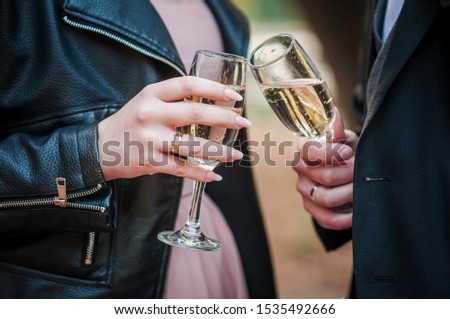 bride and groom clink glasses with champagne