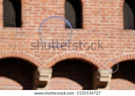 soap bubble on the background of the building, airy and colorful in contrast to the bricks. children's play, entertainment and decoration