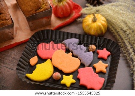 Homemade colorful Halloween sugar cookies in orange yellow and red with pumpkin decorations