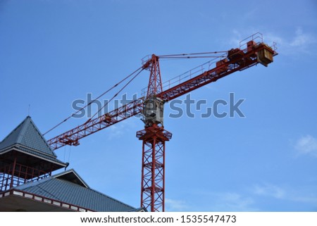 building and cranes under construction against blue sky .