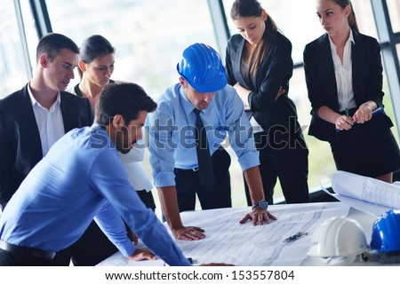 business people group on meeting and presentation  in bright modern office with construction engineer architect and worker looking building model and blueprint planbleprint plans Royalty-Free Stock Photo #153557804