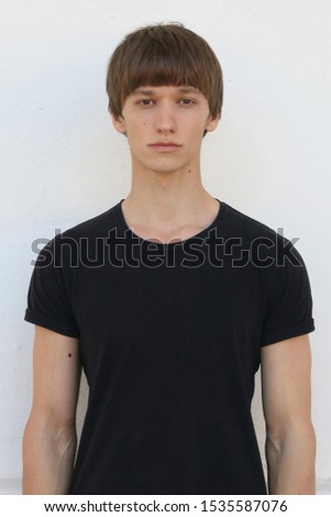 guy model man in black on a white background posing on camera portrait, for documents  with a fashion haircut