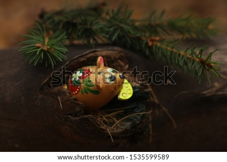 golden mouse peeks out of a forest hole