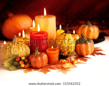Candle and pumpkins on a autumn background