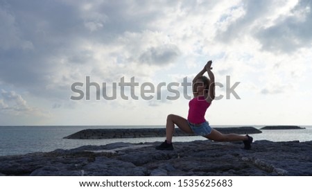 beautiful curly-haired blonde girl model on the ocean coast doing yoga. yoga meditation and flexibility without yogamat