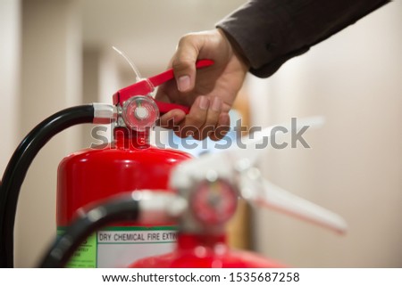 Engineer checking Pressure gauge of Fire extinguisher for fire, emergence and safety Concept.