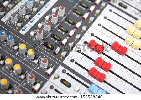 Close-up volume slide of digital sound mixer in the studio for recording, editing, and Sound system control concept.