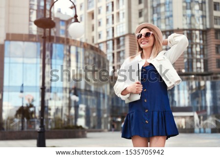 Beautiful woman with laptop on city street. Space for text