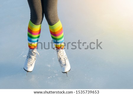 Pair of legs shod ice skates on ice in winter