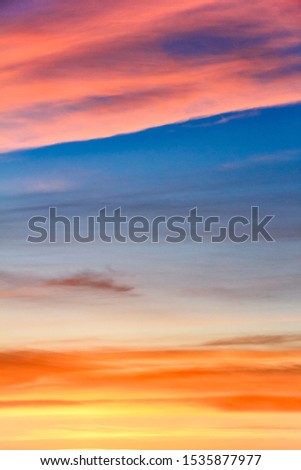 Beautiful sunset with fiery pink  clouds. Colorful cloudscape blue sky. Blurred natural vertical background.