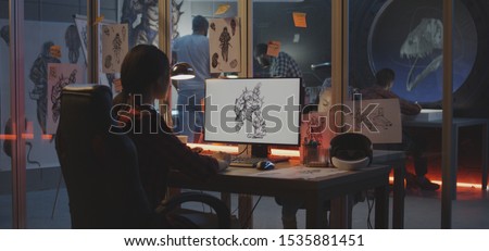 Medium shot of a young woman drawing game art on computer