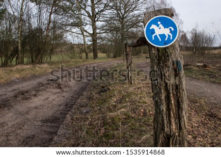 Sign for a hors riding track.