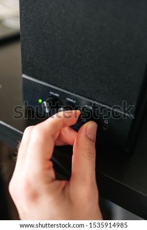 A close-up photo of a male hand that holds out his hand to increase the bass. Selective focus.